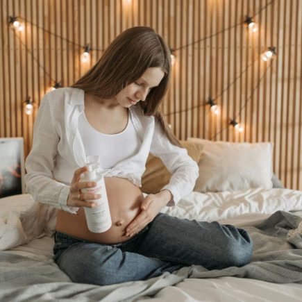 Une femme enceinte passe de la lotion sur son ventre