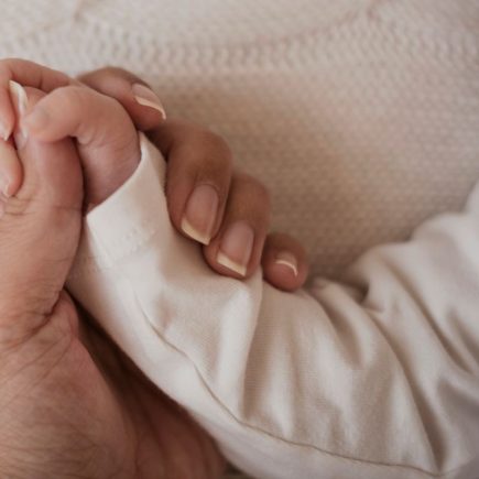 deuil grossesse mère tenant main bébé