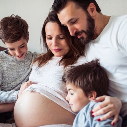 femme enceinte avec son mari et ses deux enfants