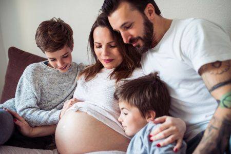 femme enceinte avec son mari et ses deux enfants